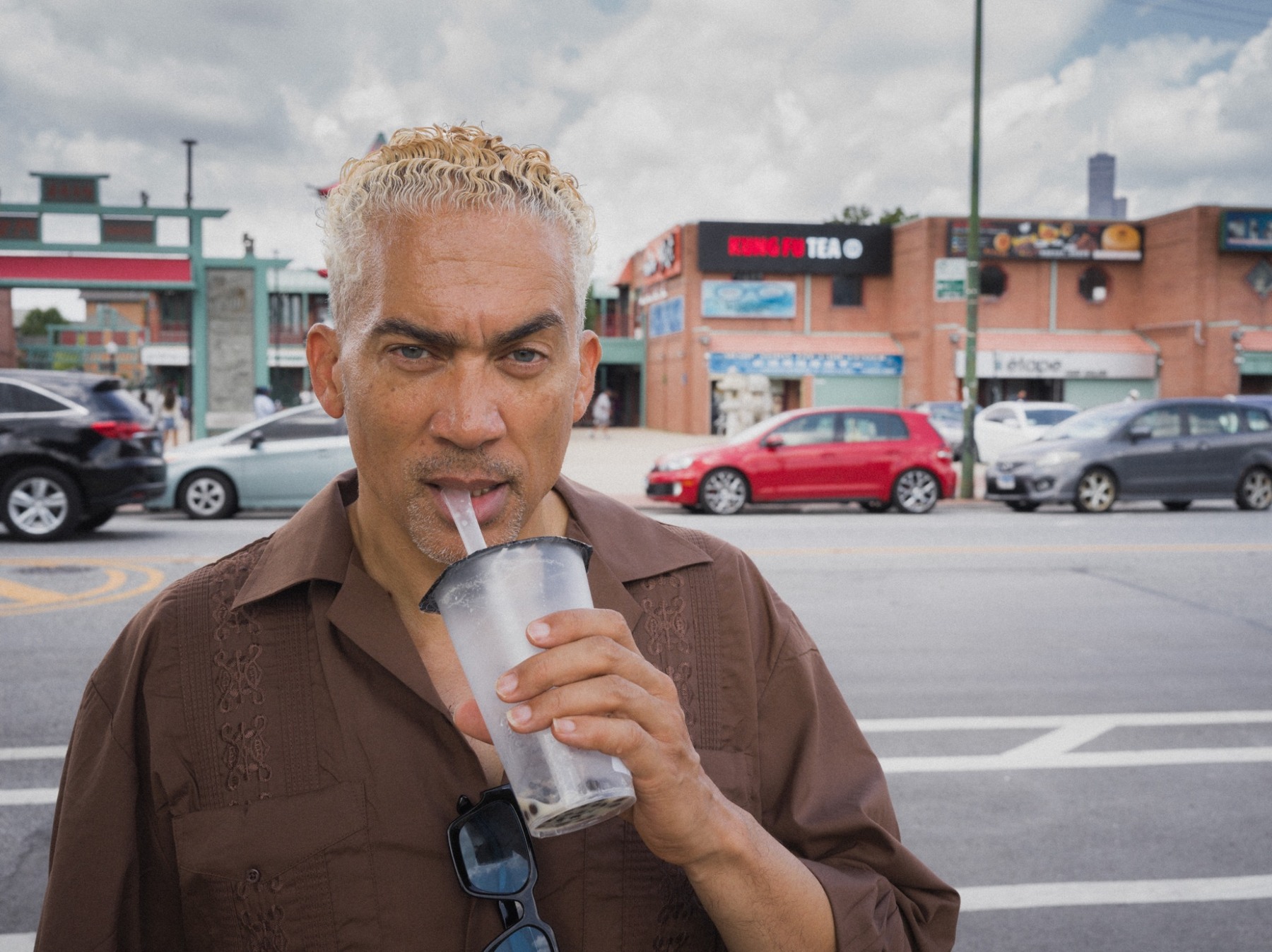 A man drinking from a cup on a city street