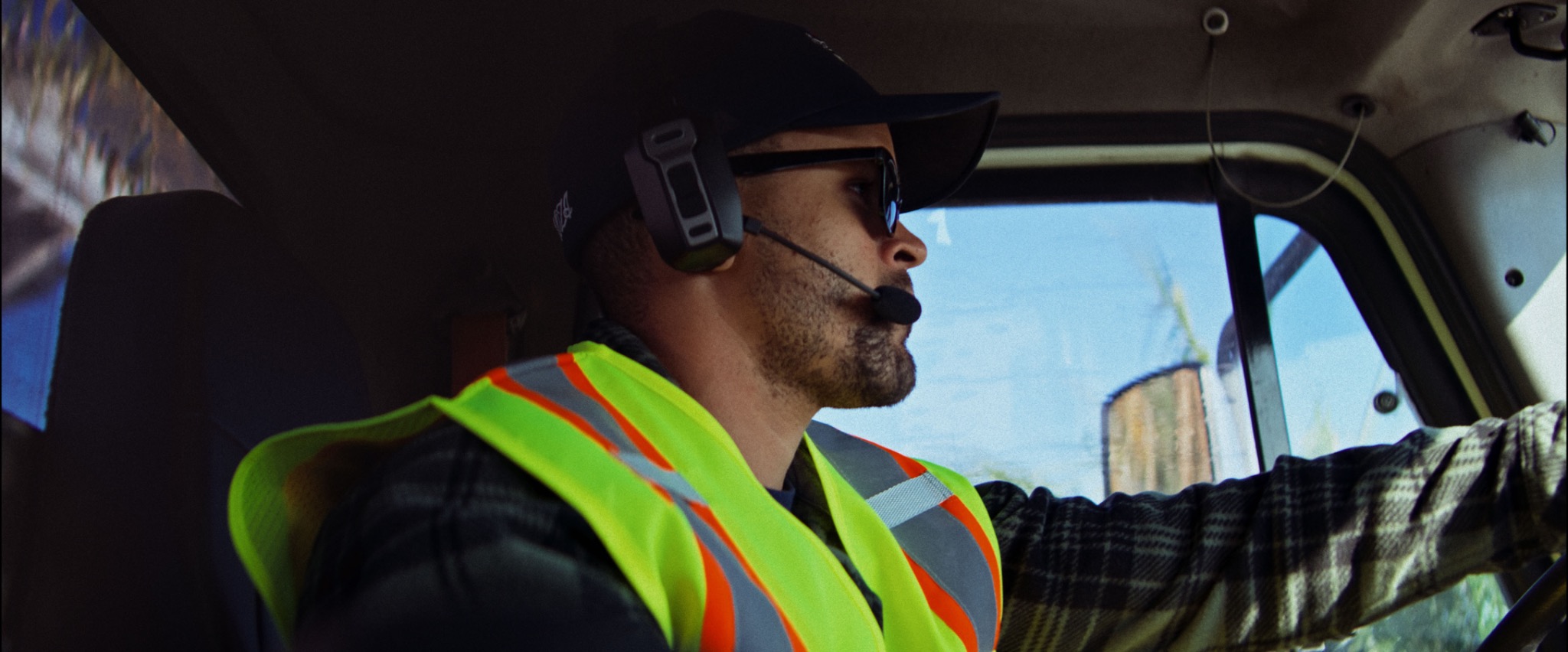 Worker driving while wearing the Black & Gray headset