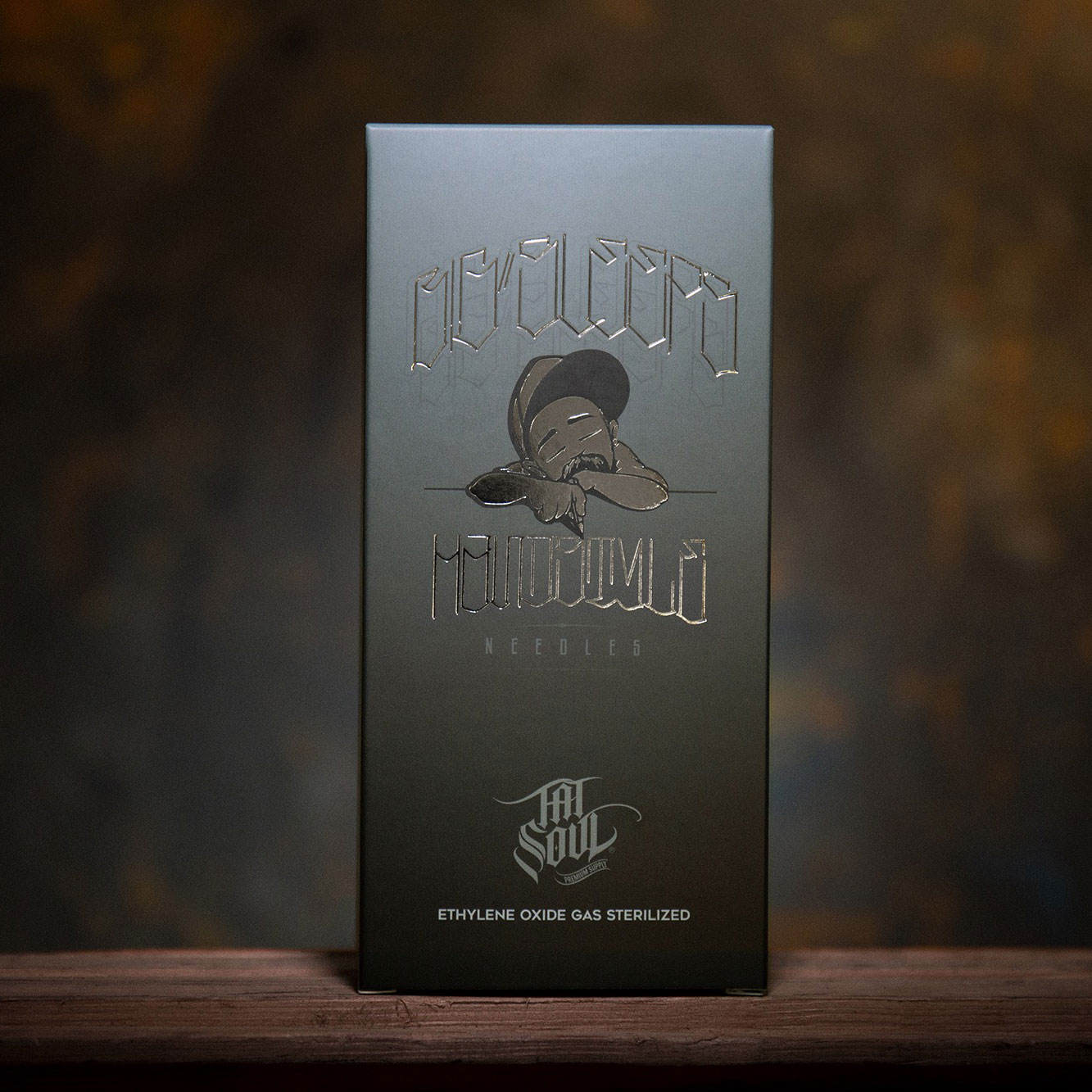 ENSO tattoo needle packaging photographed against a warm studio background